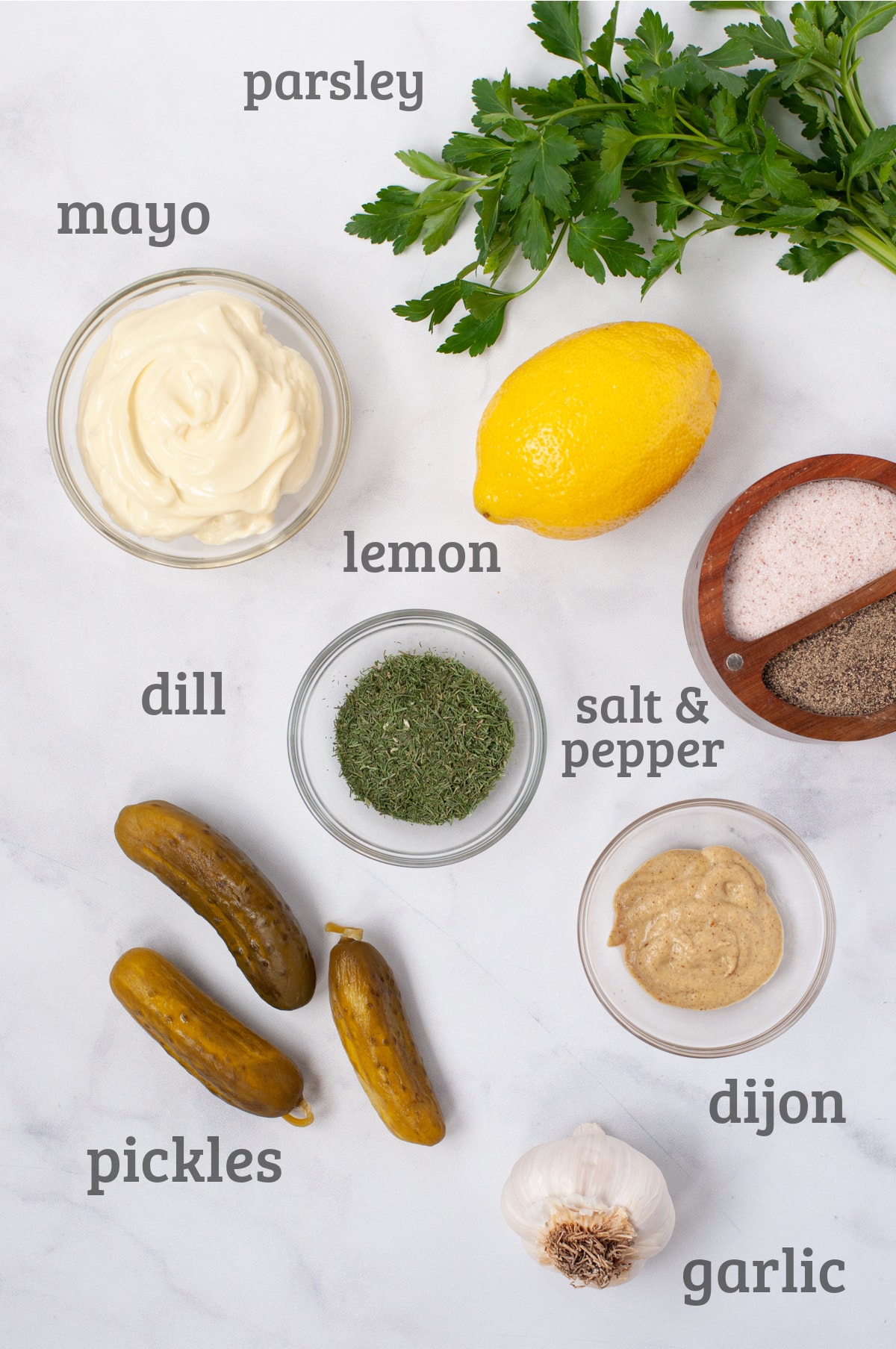 Ingredients for tartar sauce - parsley, lemon, mayo, dill, dijon, pickles, garlic, salt and pepper