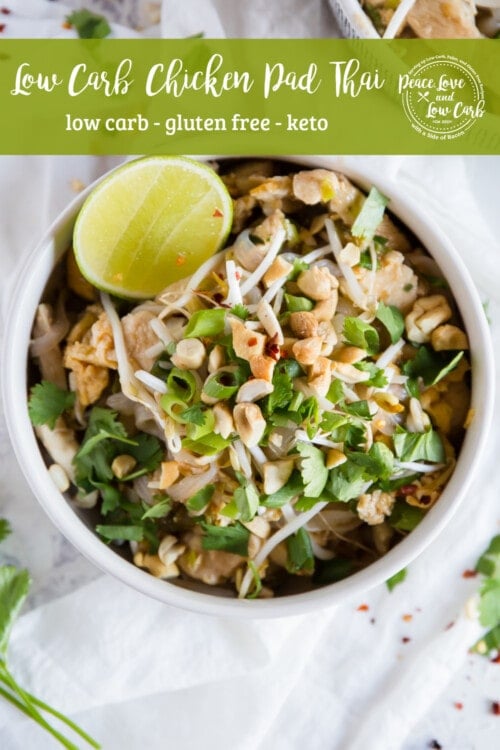 Keto Chicken Pad Thai garnished with red pepper flakes, cilantro, and lime in a white bowl on a white background with extra garnish sprinkled around.