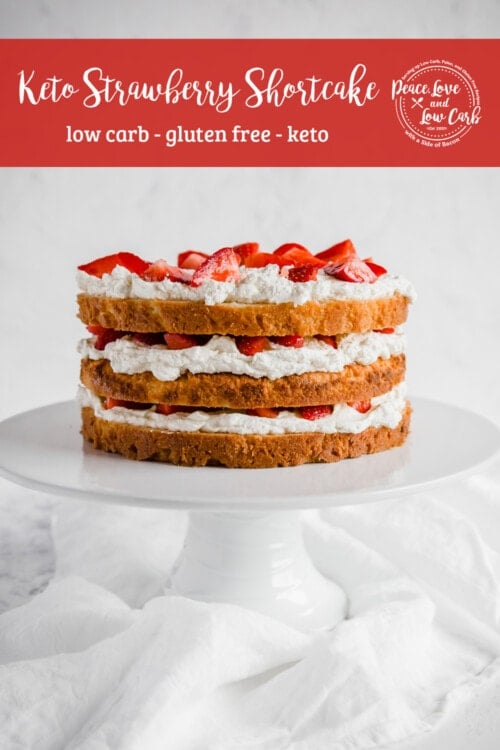 low carb Strawberry shortcake, with layers of fresh cream and strawberries on a cake stand