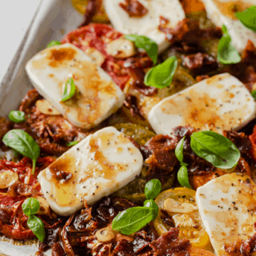 a sheet pan loaded up with fresh mozzarella, sliced heirloom tomatoes, bacon, garlic, and fresh basil.