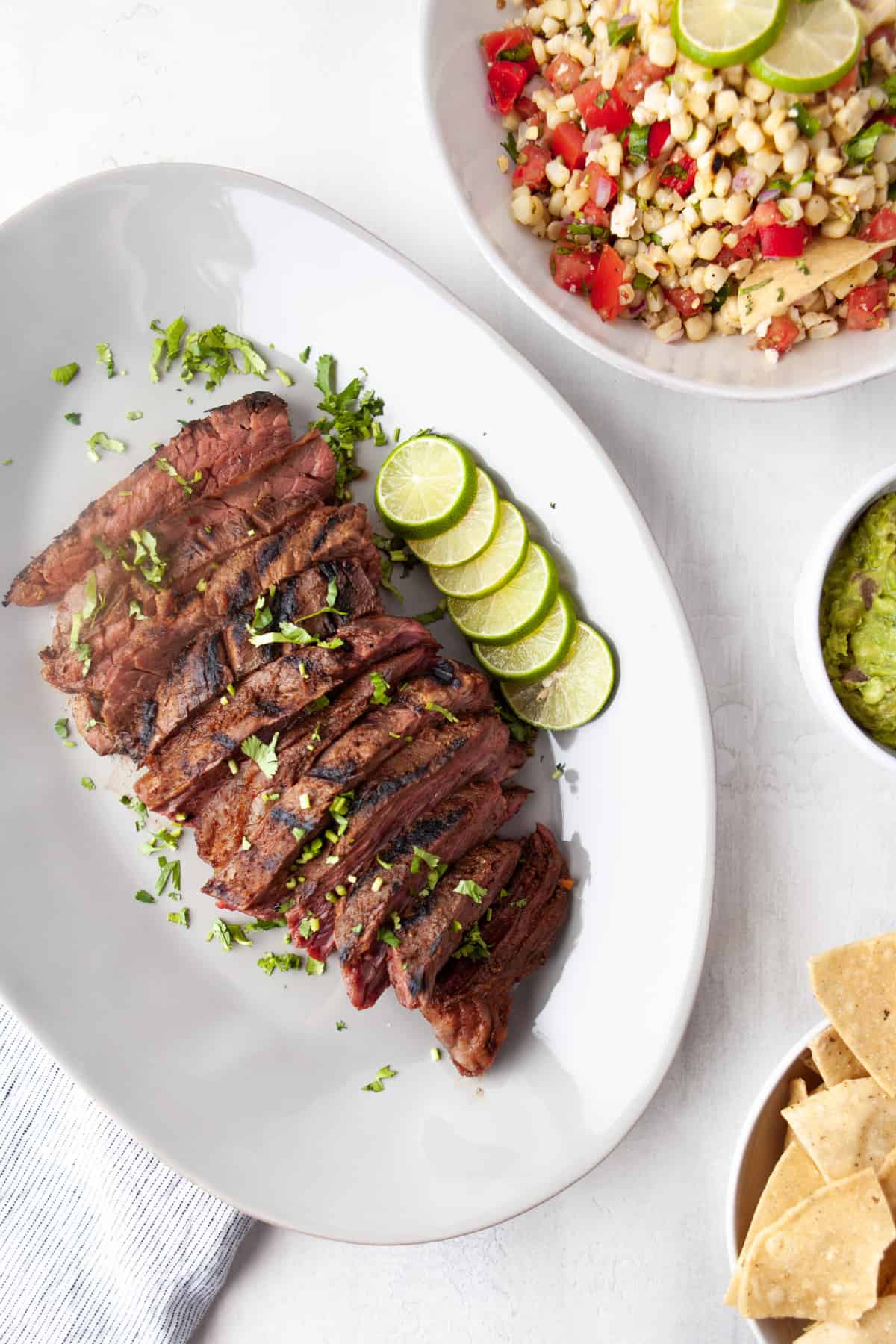 grilled flank steak sliced against the grain and served with limes and cilantro