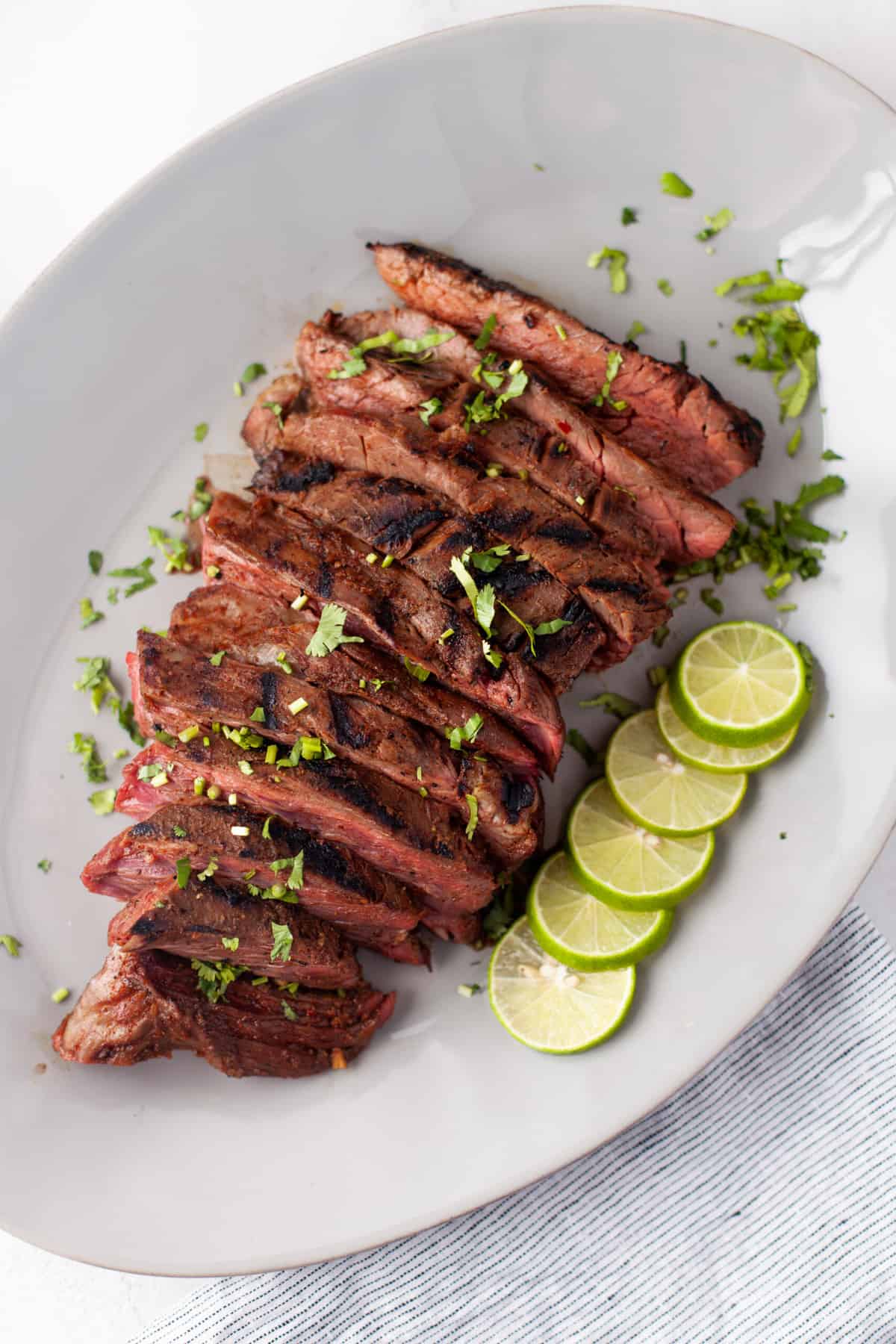 grilled flank steak sliced against the grain and served with limes and cilantro 