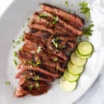 grilled flank steak sliced against the grain and served with limes and cilantro.