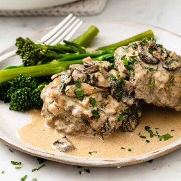 beef stroganoff burgers on a white ceramic plate, served with broccoli.
