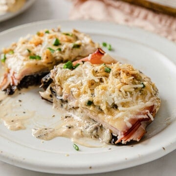 a rimmed baking sheet with parchment paper, topped with portobello mushrooms, cooked with Cordon Bleu toppings.