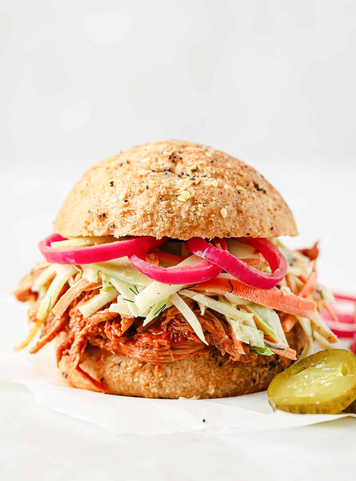 barbecue pulled pork sandwich with keto buns, barbecue pork, broccoli slaw, and pickled red onions