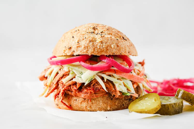 barbecue pulled pork sandwich with keto buns, barbecue pork, broccoli slaw, and pickled red onions