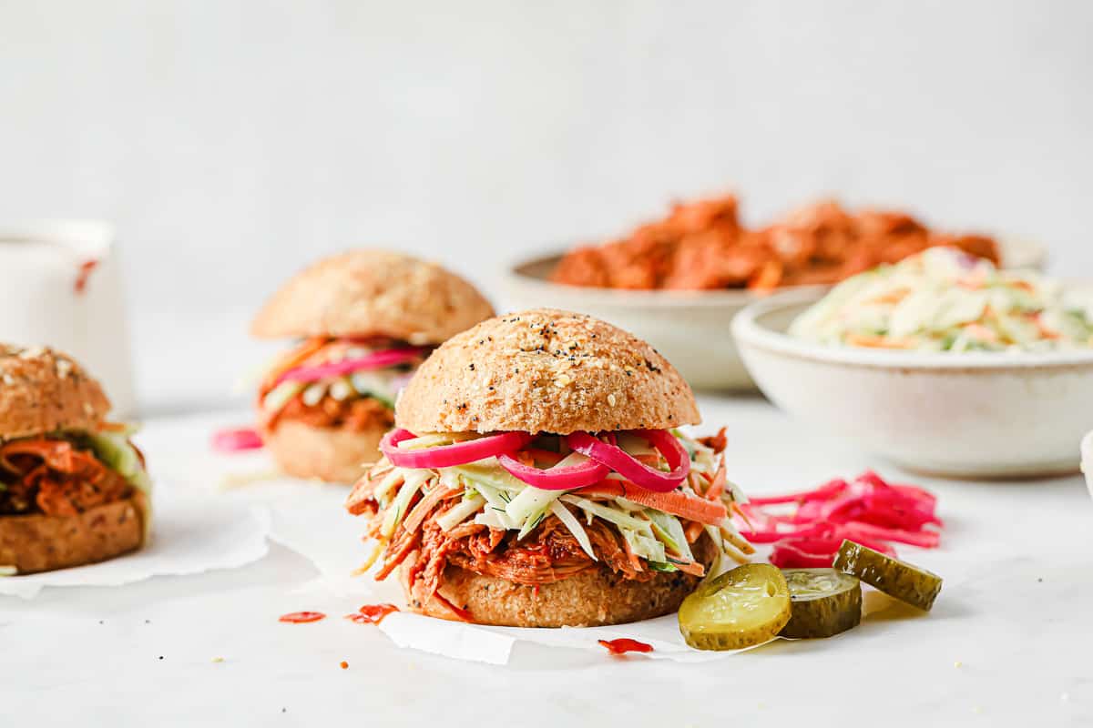 barbecue pulled pork sandwich with keto buns, barbecue pork, broccoli slaw, and pickled red onions