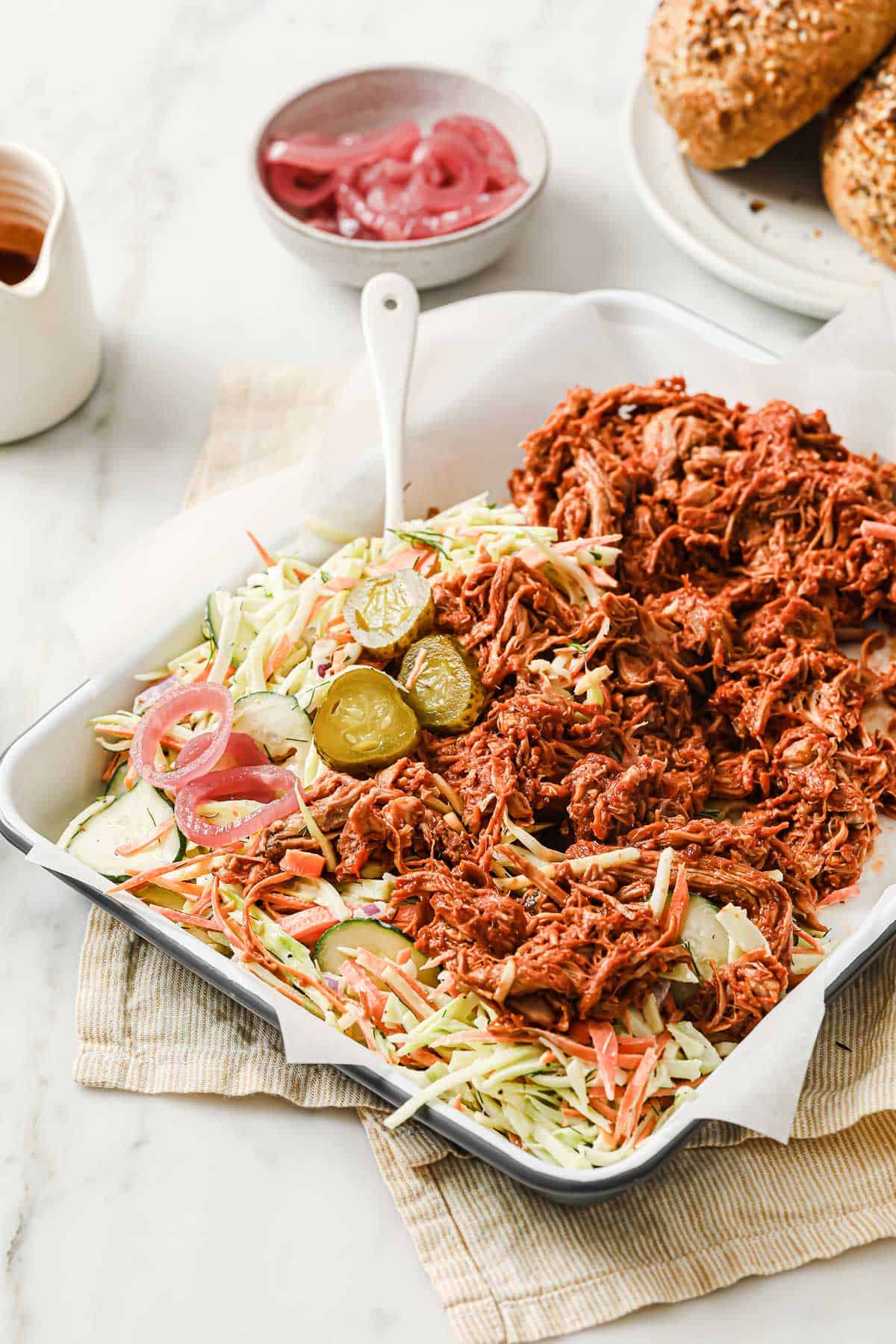 a tray of cucumber dill broccoli slaw, plated with slow cooker keto barbecue pulled pork