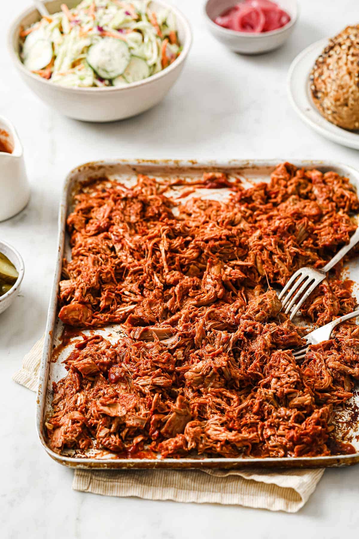 cooked and shredded pork butt, tossed with keto barbecue sauce, on a sheet pan