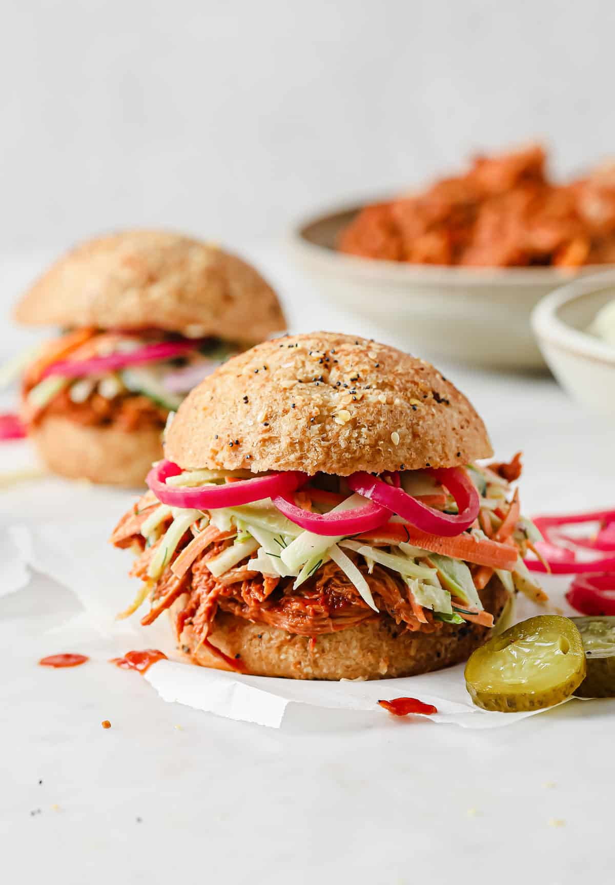 barbecue pulled pork sandwich with keto buns, barbecue pork, broccoli slaw, and pickled red onions