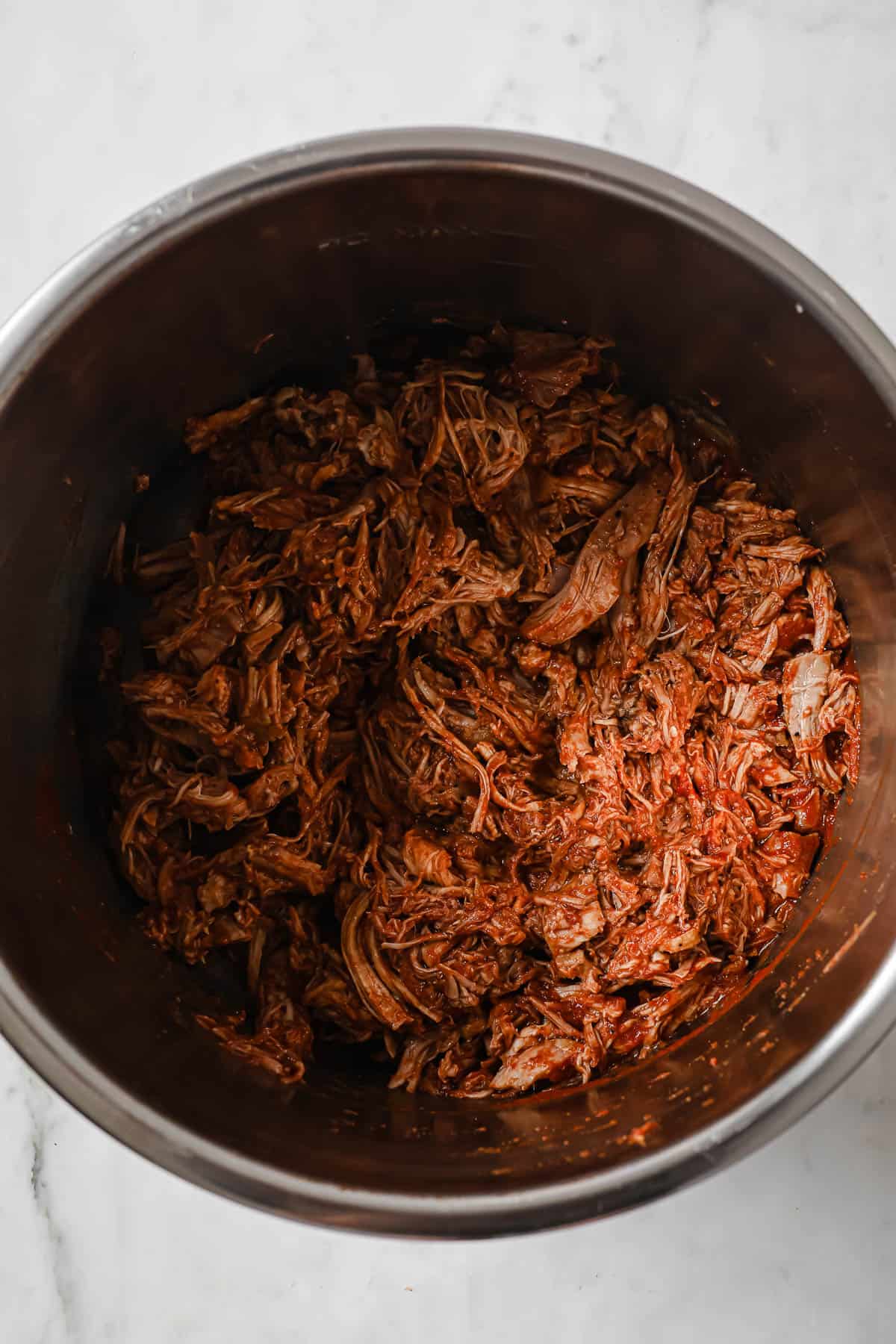 cooked and shredded pork shoulder, sauced with barbecue sauce in a slow cooker