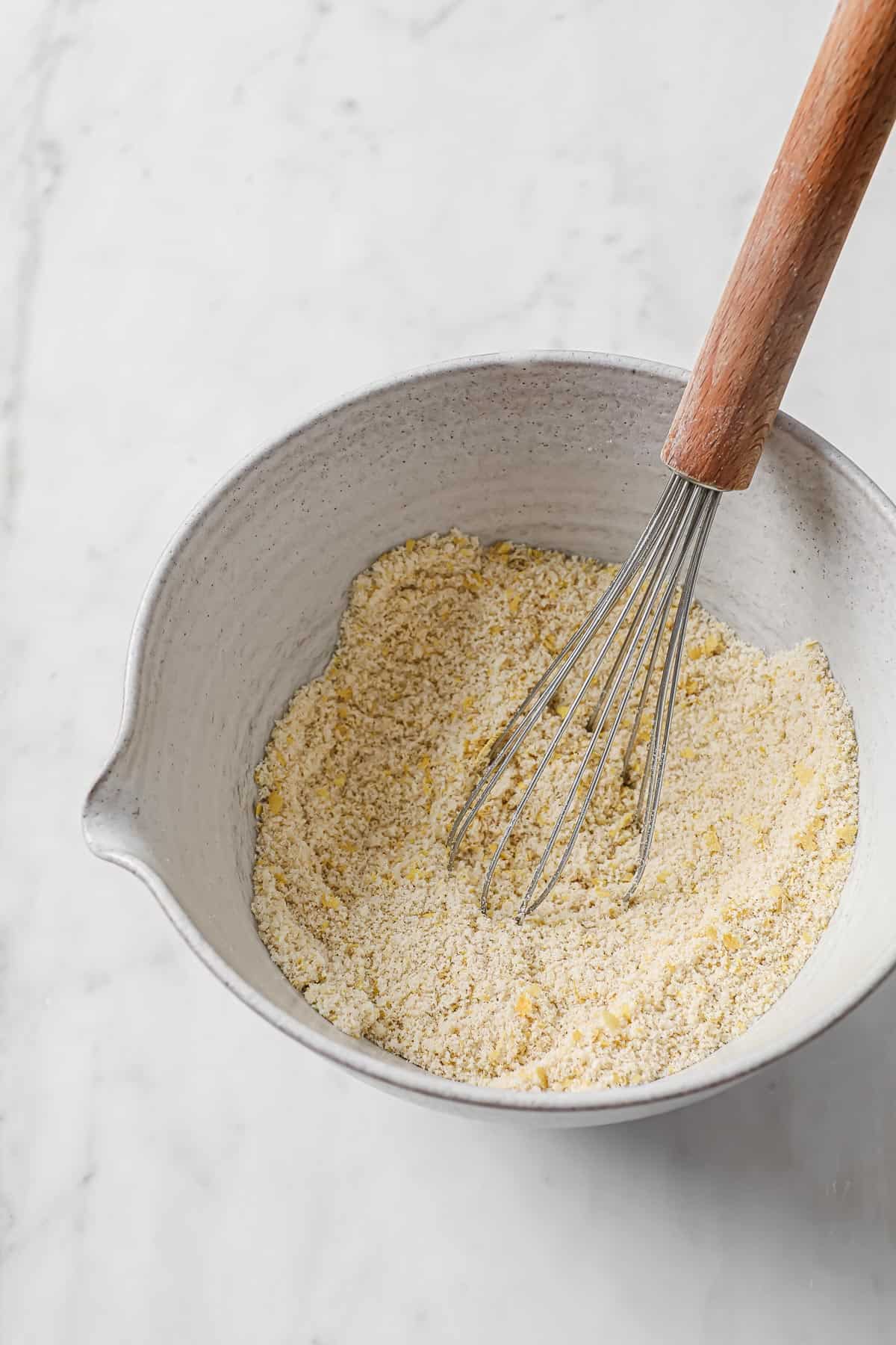 Dry ingredients for a keto bread recipe in a mixing bowl, with a whisk