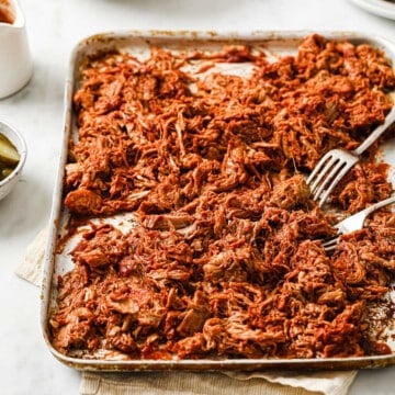 keto barbecue pulled pork, shredded and sauced on a sheet pan.