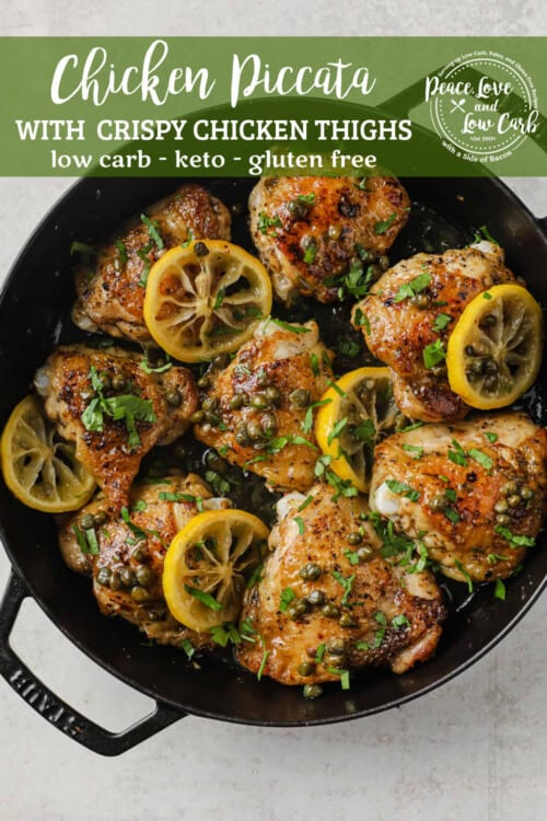 cast iron skillet full of crispy chicken thighs, lemon, capers, and fresh herbs