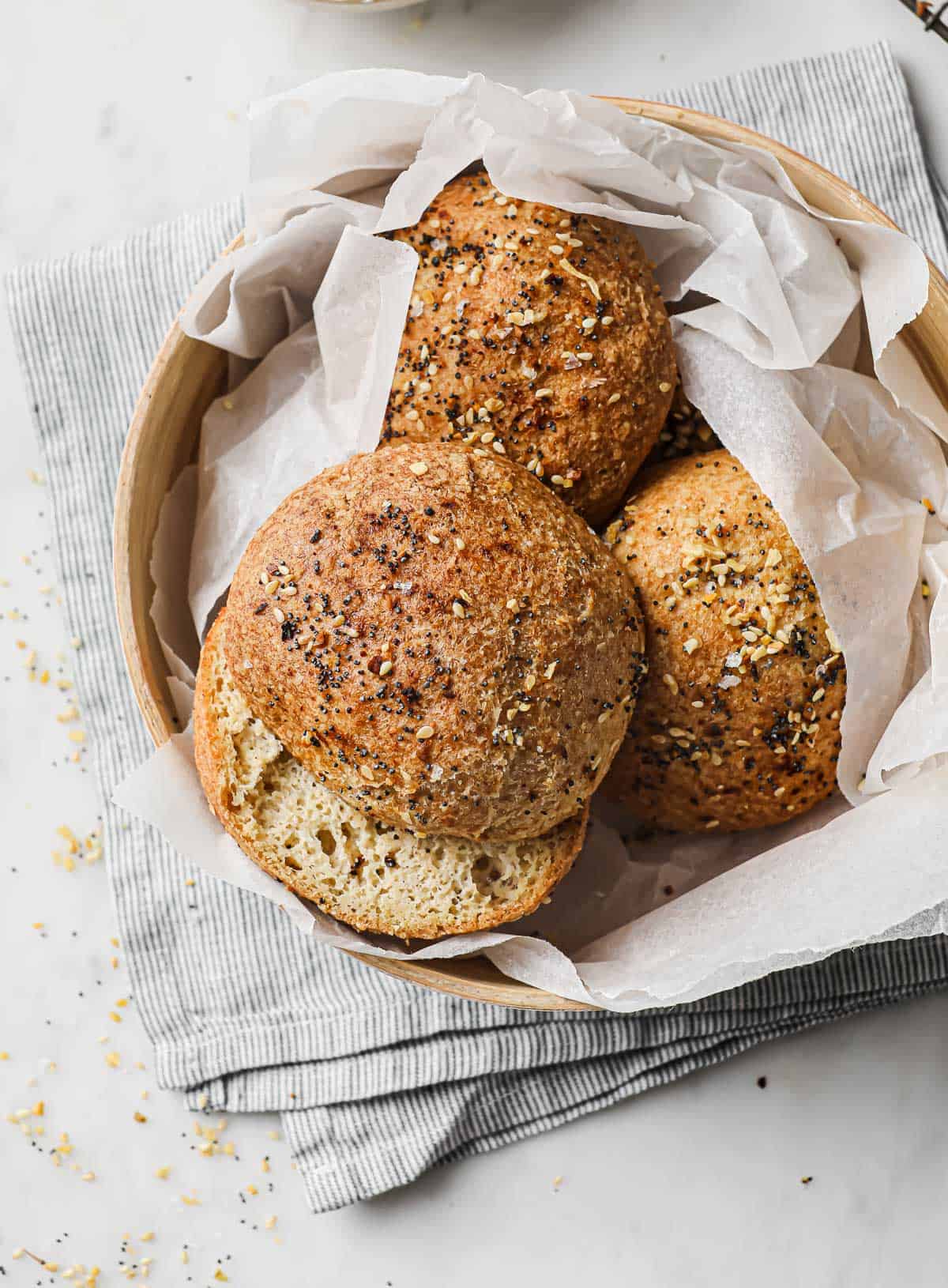 low carb sandwich rolls topped with everything bagel seasoning in a basket lined with parchment paper