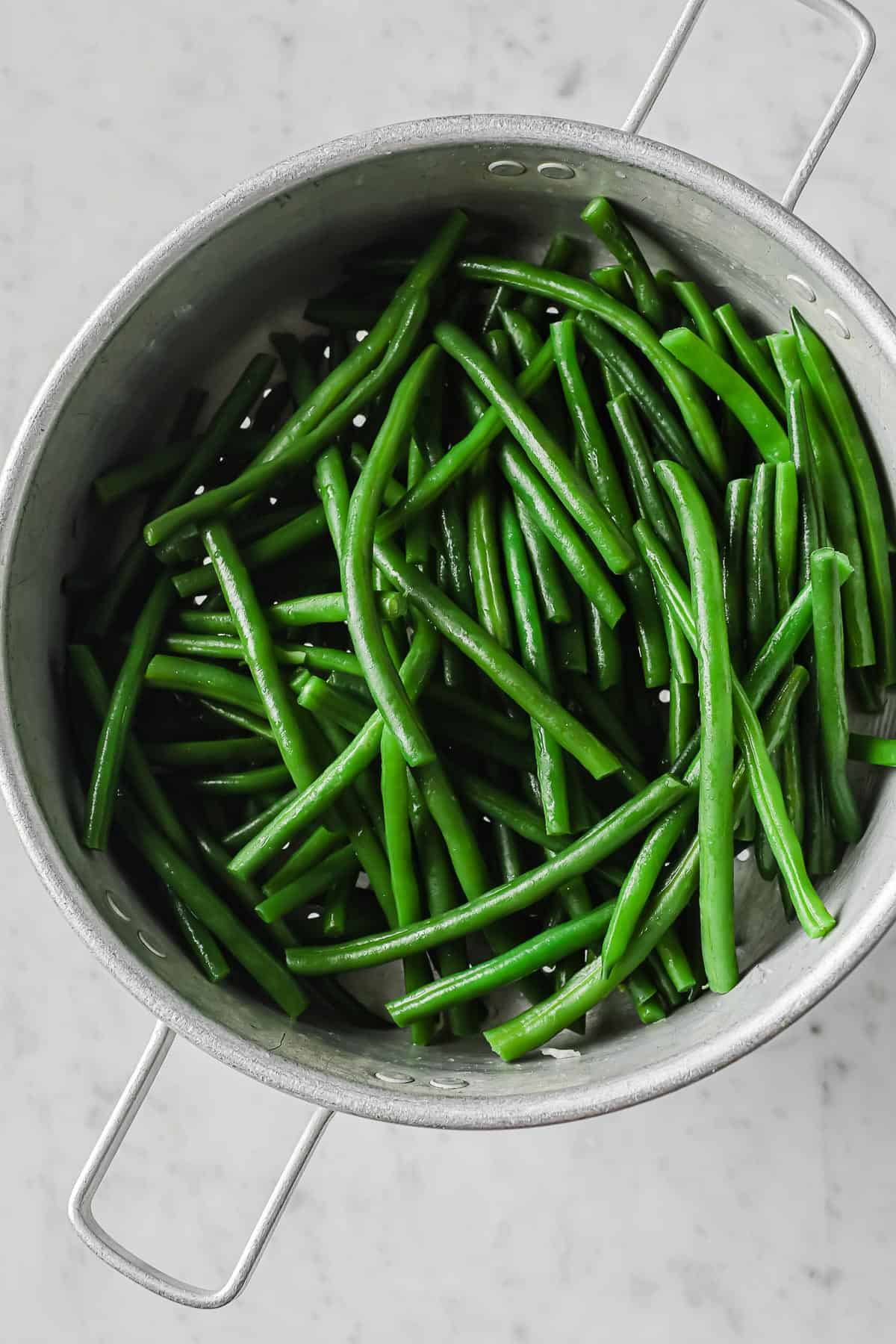 fresh cooked green beans in a colander