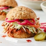 barbecue pulled pork sandwich with keto buns, barbecue pork, broccoli slaw, and pickled red onions.