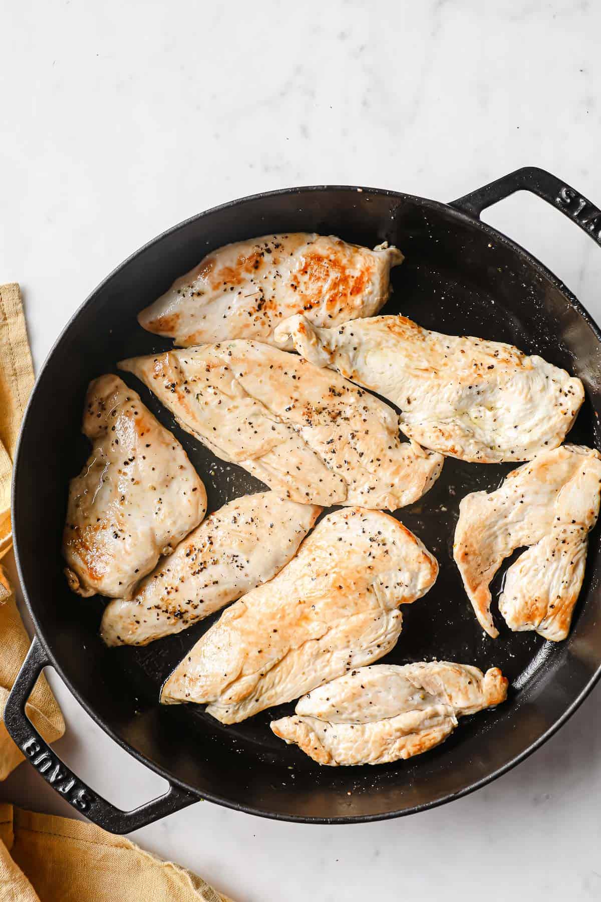 pan-seared chicken breasts, seasoned with salt and pepper, in a cast iron skillet