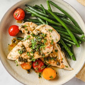 sautéed chicken cutlets with lemon butter caper sauce, served with blistered tomatoes and green beans