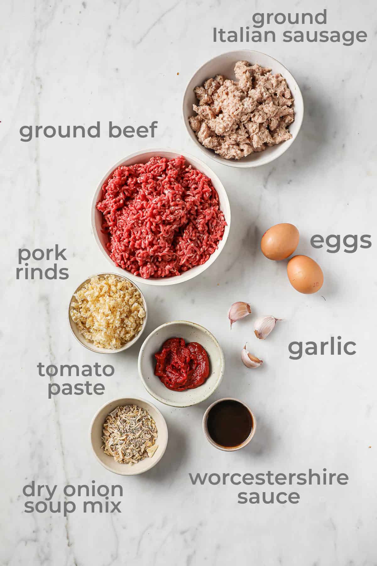 ingredients for meatloaf - beef, sausage, tomato paste, eggs, onion soup, garlic