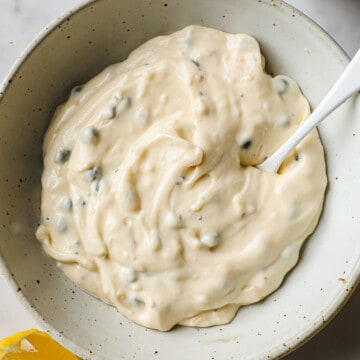 A mixing bowl with mayo, capers, lemon juice, garlic, salt, dijon, and capers