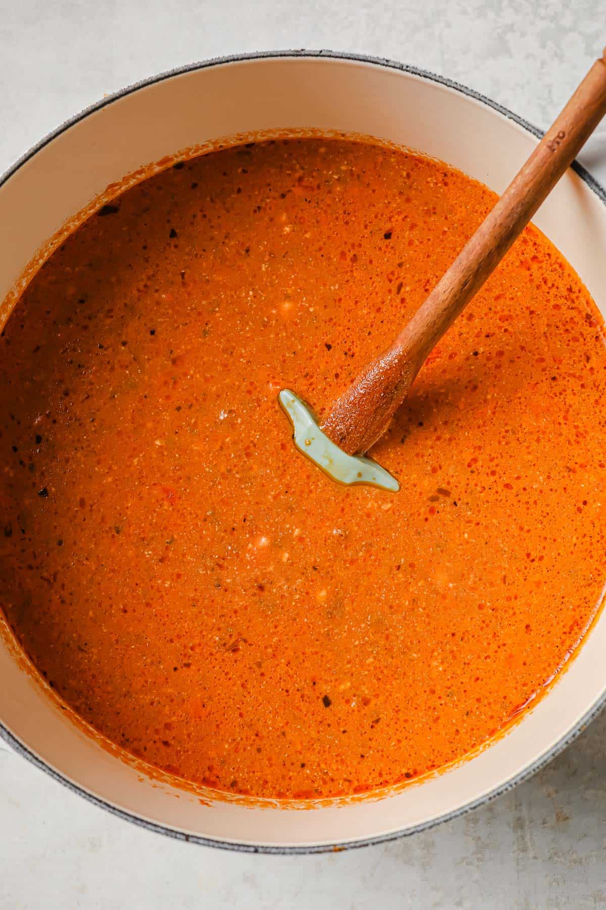 a dutch oven full of rich, creamy tomato soup