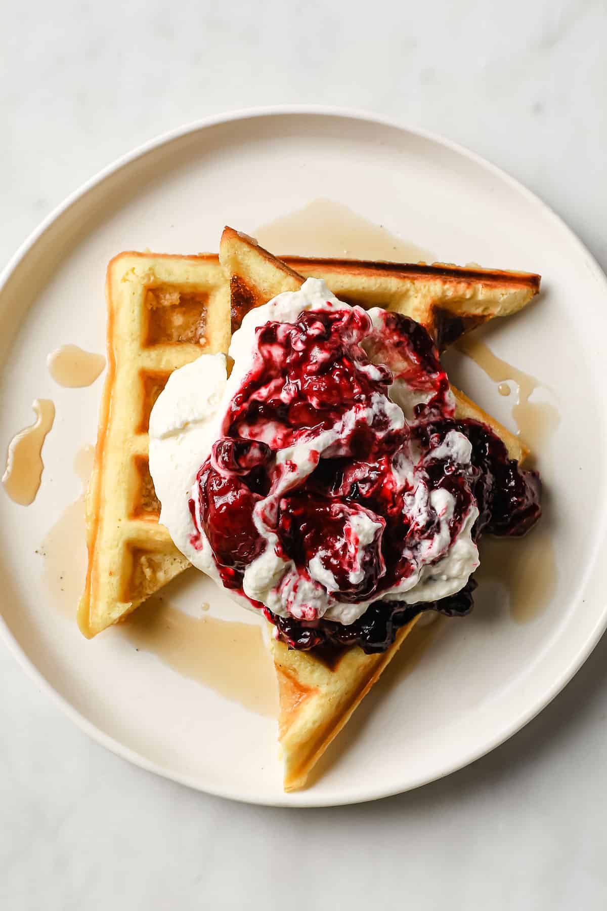 keto waffles topped with syrup, low carb jam, and homemade whipped cream