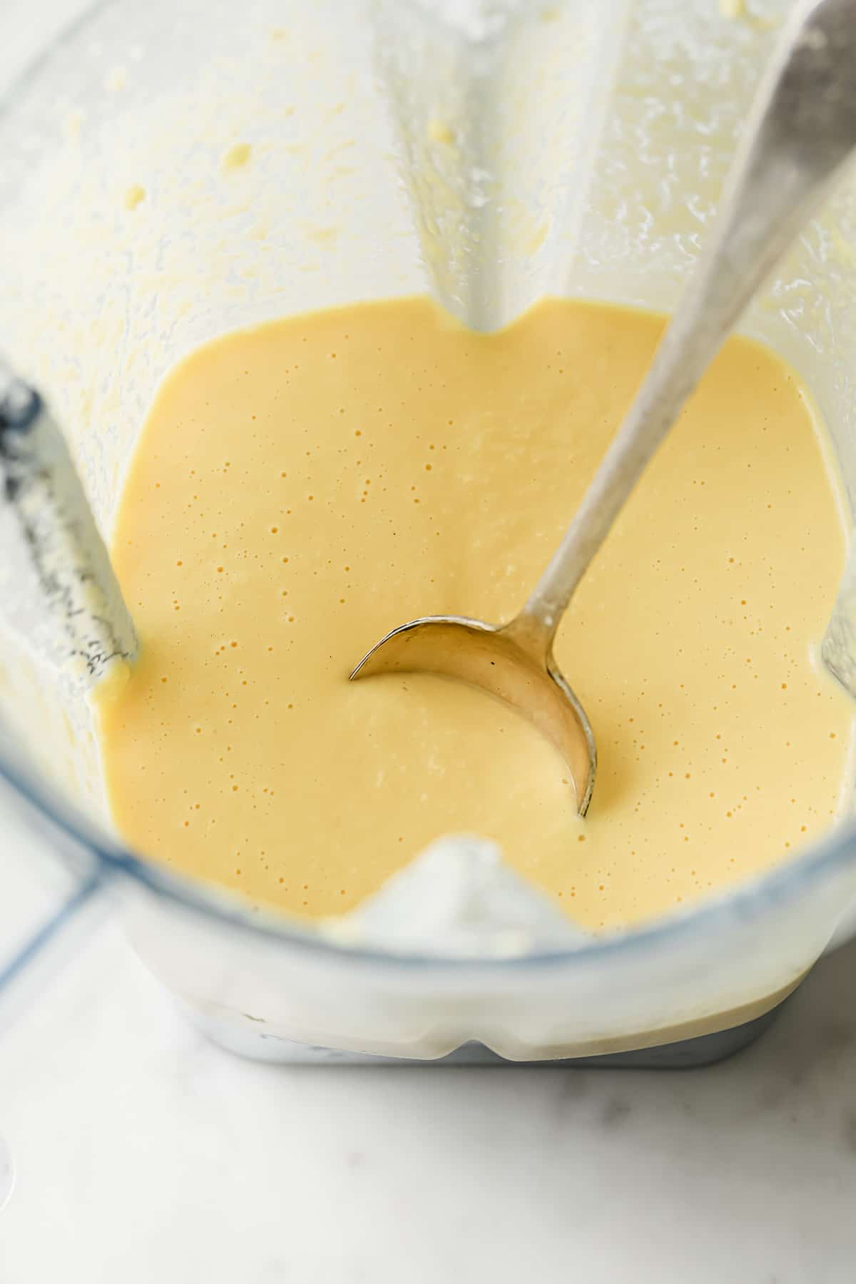 A blender with coconut flour, eggs, cream cheese, vanilla, and heavy cream in it
