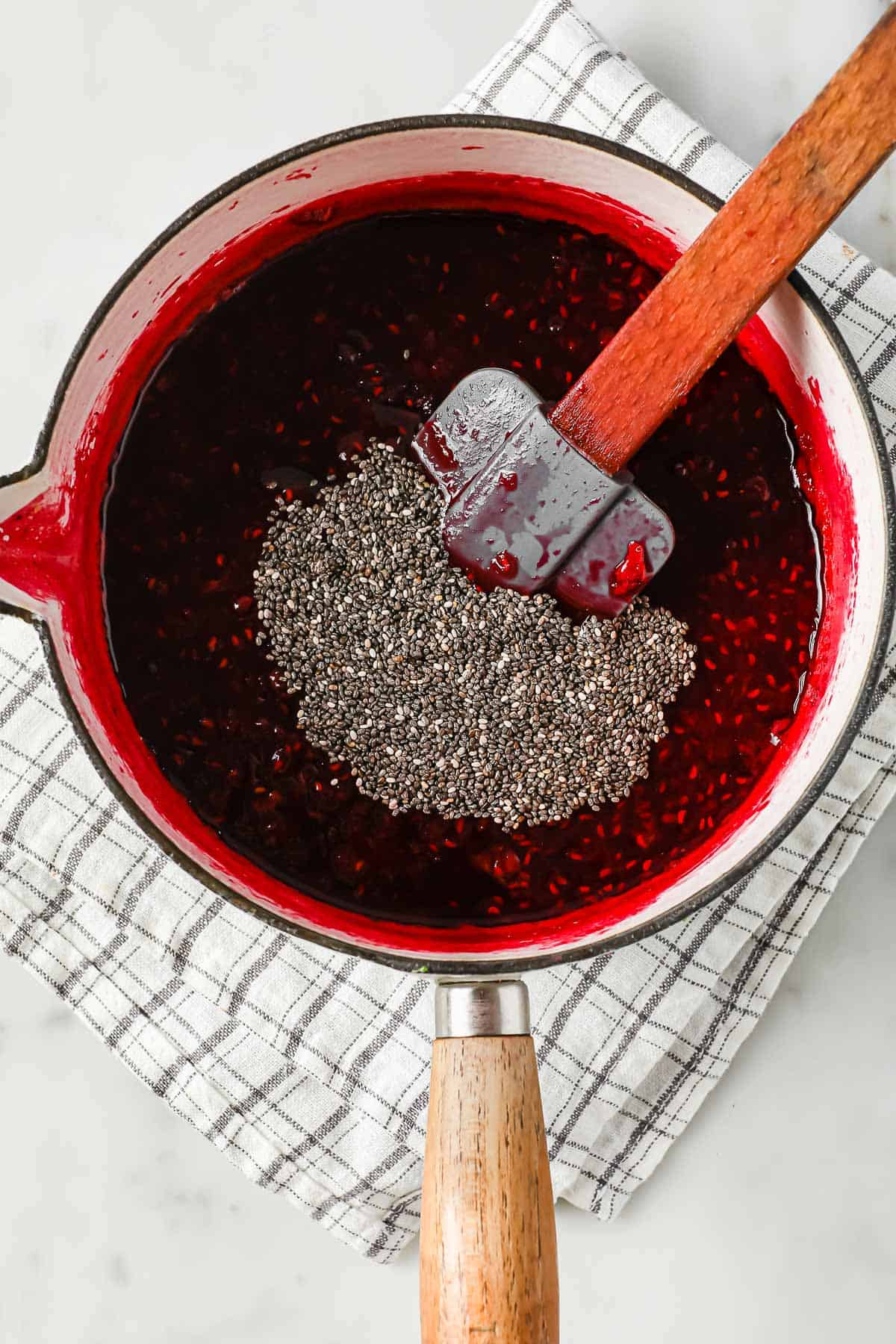 A sauce pan with homemade low carb mixed berry jelly with chia seeds
