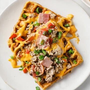 egg based omelets cooked in a waffle iron, topped with ham, sausage, peppers, onion, mushrooms, green onion and cheese sauce.