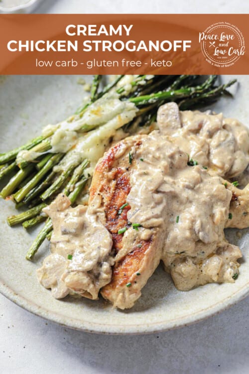 a plate with cheesy asparagus and seared chicken, topped with sour cream sauce.