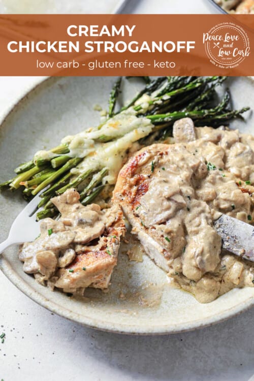 a plate with cheesy asparagus and seared chicken, topped with sour cream sauce.