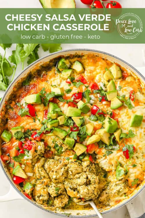 An enameled cast iron skillet filled with a cheesy chicken casserole, topped with salsa verde, cheese, pico de Gallo, avocado, and cilantro.