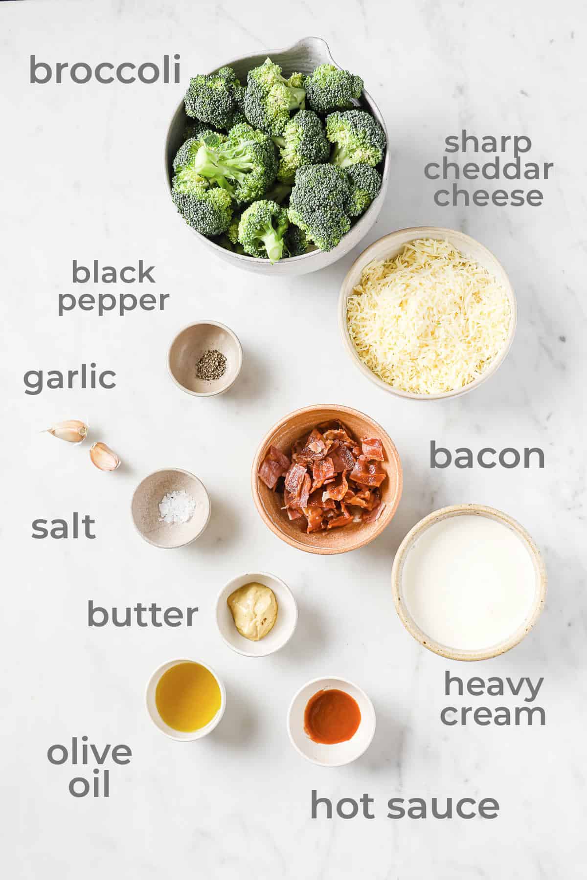 Individual ingredients in separate bowls to make roasted broccoli, homemade cheese sauce, and crispy bacon.