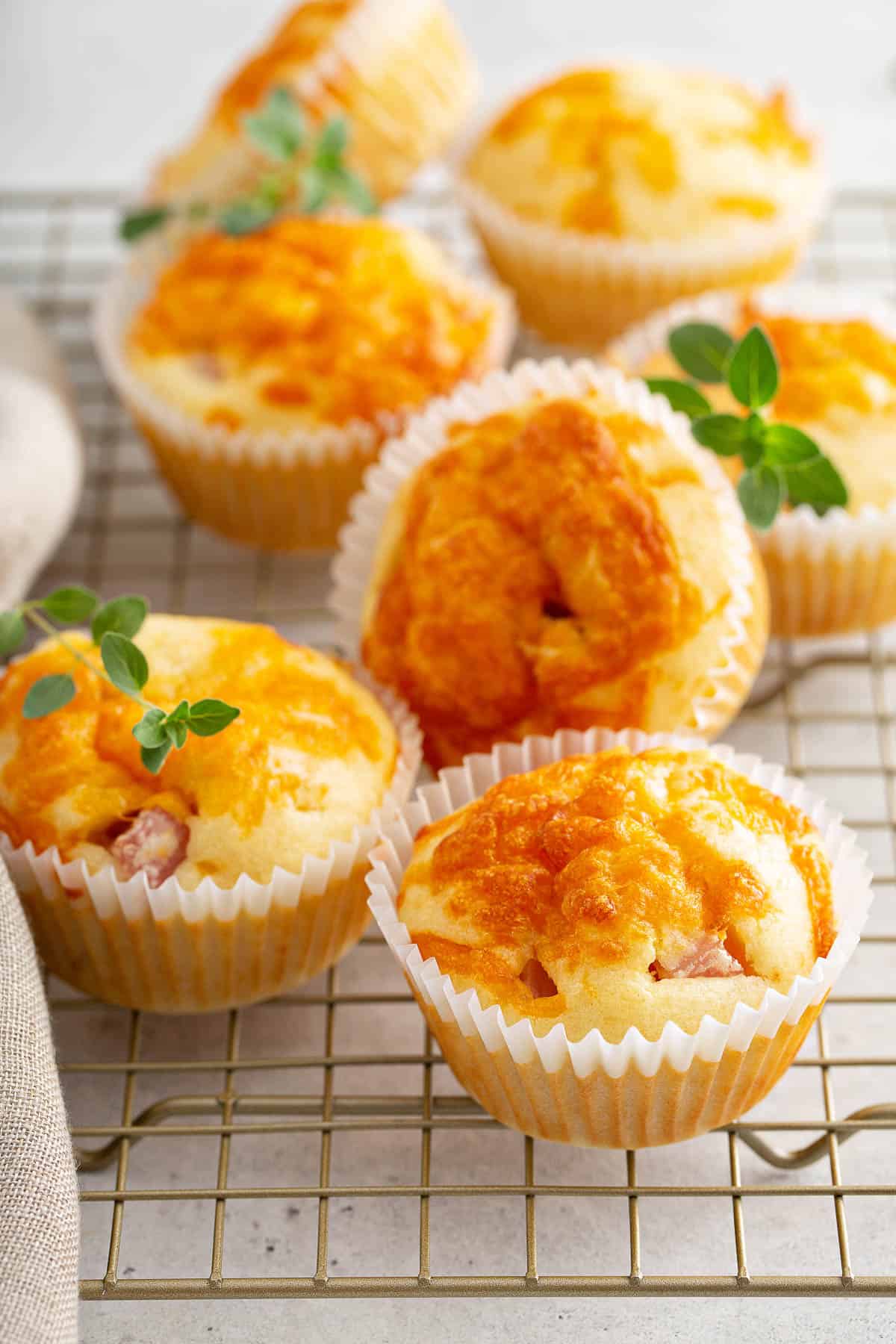  Egg muffins, garnished with fresh herbs, cooling on a wire rack.