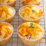 Ham and Cheese Egg muffins, garnished with fresh herbs, cooling on a wire rack.