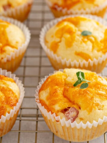 Ham and Cheese Egg muffins, garnished with fresh herbs, cooling on a wire rack.