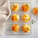Ham and Cheese Egg muffins, garnished with fresh herbs, cooling on a wire rack.